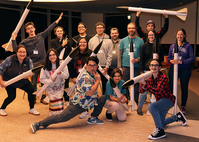 A group of students and instructors posing with their completed rockets